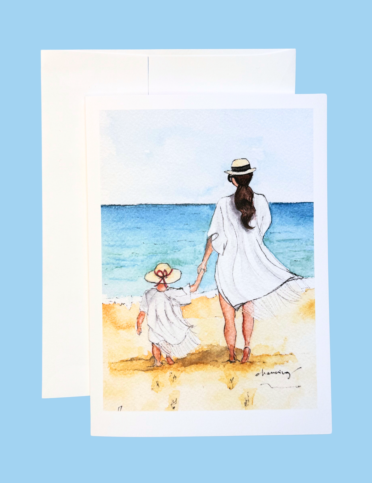 back of a woman with brunette ponytail and a child walking on a beach together