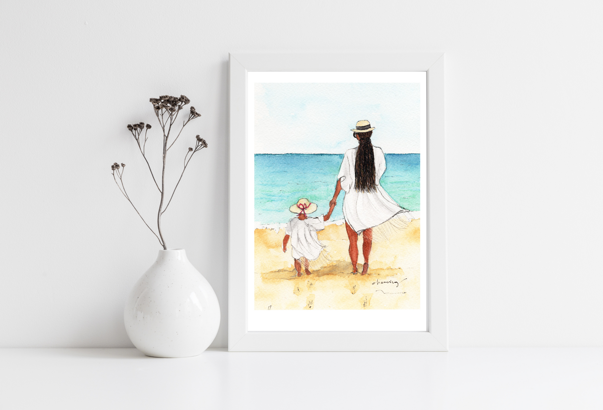 back of a woman with long black braids and a child walking on a beach together.